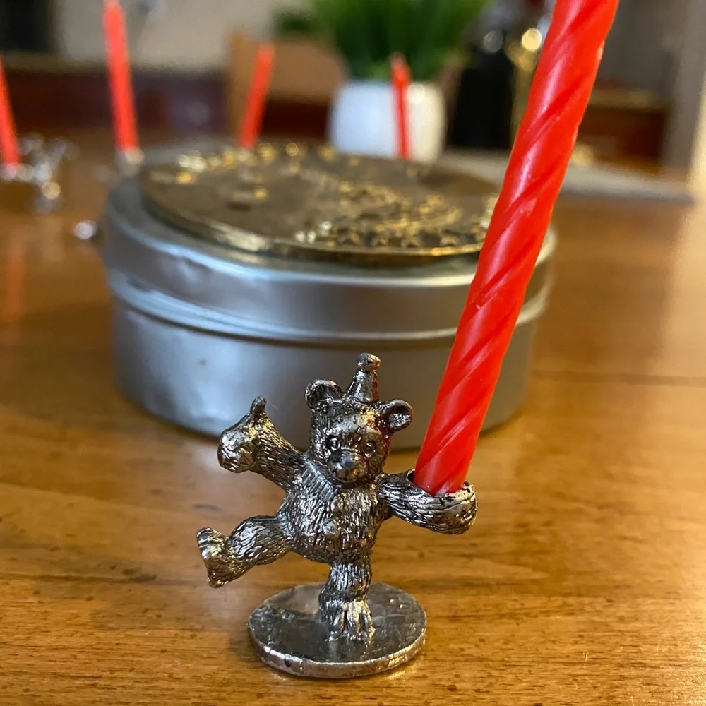 Set of animal candle holders stored in a metal tin.